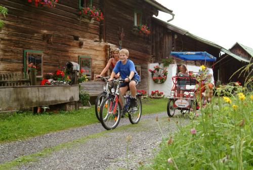 a young boy riding a bike next to a house at Familienhotel Sonngastein in Bad Gastein