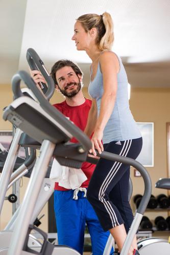 a woman standing next to a man on a treadmill at Familienhotel Sonngastein in Bad Gastein