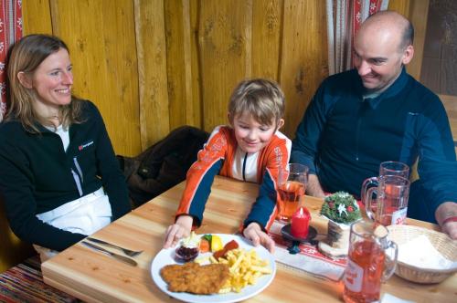 a family sitting at a table with a plate of food at Familienhotel Sonngastein in Bad Gastein