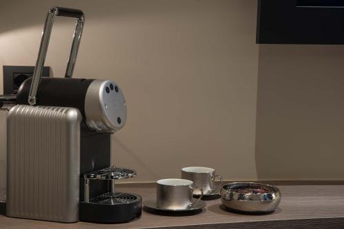 a coffee maker and two cups on a table at Navona Street Hotel in Rome