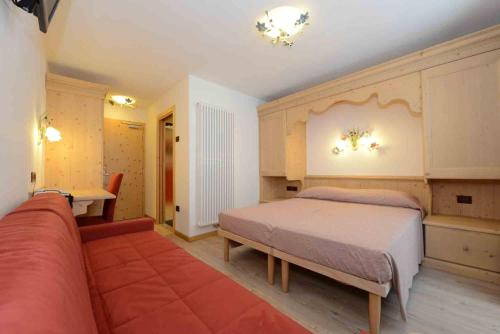 a bedroom with a bed and a couch at Hotel Stella in Passo del Tonale