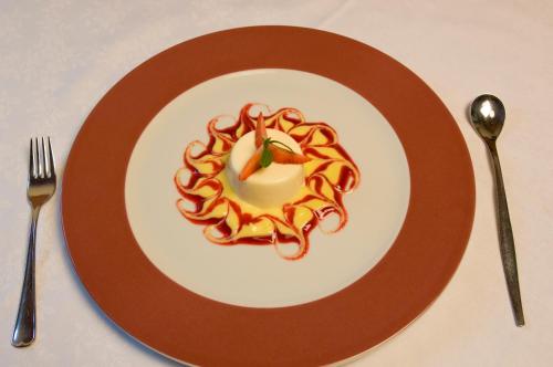 a plate with a dessert with a candle on it at Hotel Löwenwirt in Cermes