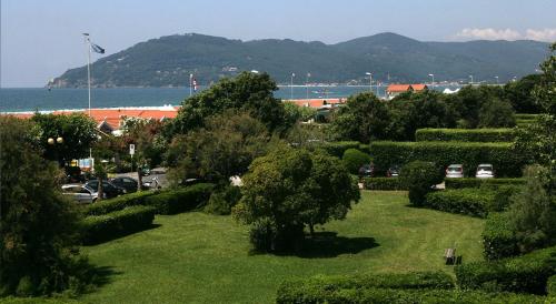 a park with bushes and trees and a beach at Hotel Tenda Rossa in Marina di Carrara