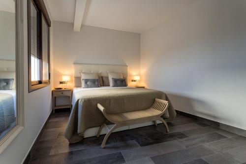 a bedroom with a bed with a chair and two lamps at Cañete Medica House in Almodóvar del Río