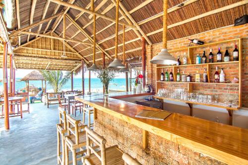 - un bar dans un restaurant avec vue sur l'océan dans l'établissement Local Beach Homestay, à Hội An