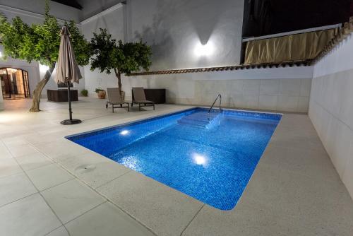 a swimming pool with blue water in a room at Cañete Medica House in Almodóvar del Río