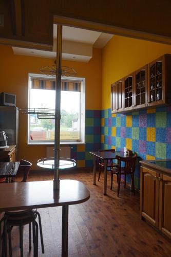 a kitchen with tables and chairs and a window at Hotel Erfolg in Daugavpils