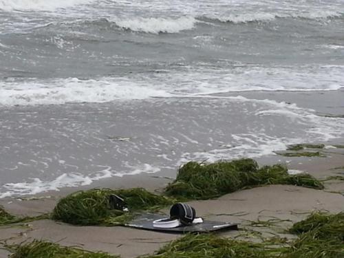 a surfboard laying on the sand on the beach at Strandhaus Buchtmitte in Haffkrug