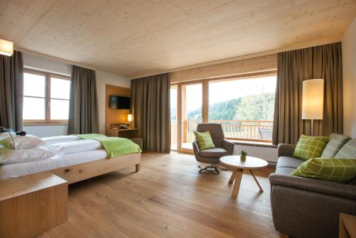 a hotel room with a bed and a balcony at Naturhotel Bauernhofer in Heilbrunn