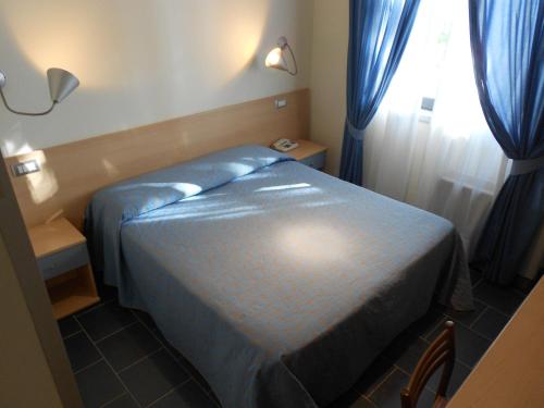 a small bedroom with a bed and a window at Hotel Tenda Rossa in Marina di Carrara