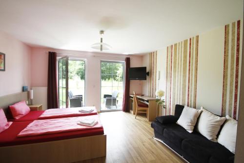 ein Schlafzimmer mit einem Bett und einem Sofa in einem Zimmer in der Unterkunft Gasthaus & Pension Am Kurfürstendamm in Burg