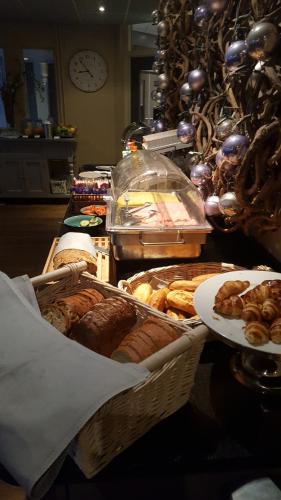 a table with baskets of different types of pastries at Hotel Medemblik in Medemblik