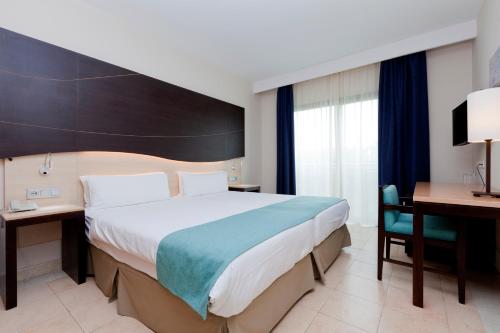 a hotel room with a large bed and a desk at Impressive Playa Granada Golf in Motril