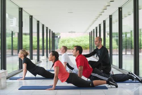 a group of people doing yoga in a building at Hotel Dolce La Hulpe Brussels in La Hulpe