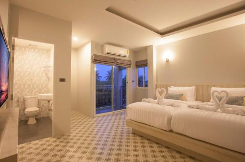 a bedroom with a large bed and a bathroom at Nature Pine Residence in Rawai Beach