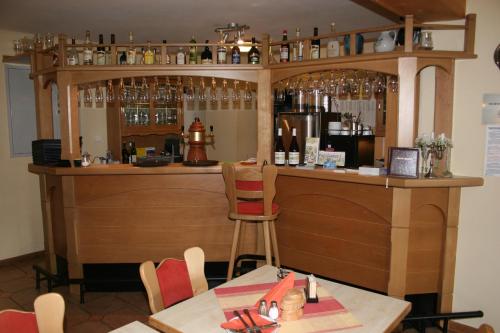 a bar in a restaurant with a table and chairs at Gasthof zur Hoffnung in Hinterhermsdorf