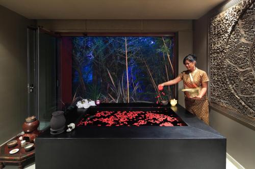 a woman standing in a room with a table with flowers at Asia Gardens Hotel & Thai Spa, a Royal Hideaway Hotel in Finestrat