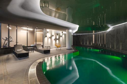 - une piscine dans un hôtel avec éclairage vert dans l'établissement Novotel Saint Brieuc Centre Gare, à Saint-Brieuc