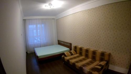 ムイティシにあるApartment on Kolpakova 41 for 4 personsのベッド1台とソファが備わる小さな客室です。