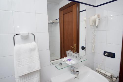 Un baño blanco con lavabo y espejo. en Hotel Marqués de la Moral, en Naveces