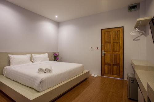 a bedroom with a bed with two towels on it at Lin House in Thalang