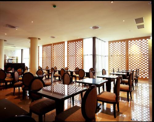 uma sala de jantar com mesas, cadeiras e janelas em G.SHOCK Motel em Pingtung