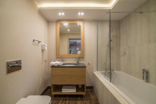 Citi Hotel's Wrocław في فروتسواف: حمام مع حوض وحوض استحمام ومرحاض