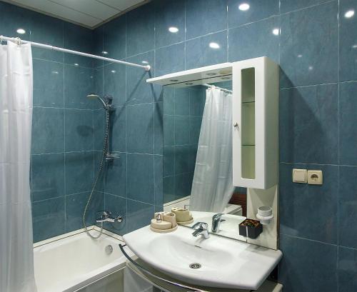 a bathroom with a sink and a mirror and a tub at Lagidze Apartment in Tbilisi City