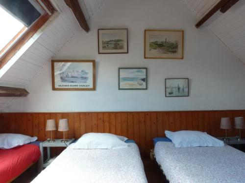 - une chambre avec 2 lits et des photos sur le mur dans l'établissement Gite des confitures à Lanvéoc-Crozon, à Lanvéoc