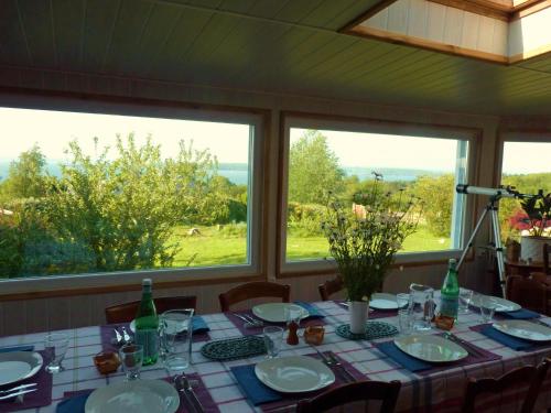 uma mesa com pratos e copos e duas janelas em Gite des confitures à Lanvéoc-Crozon em Lanvéoc