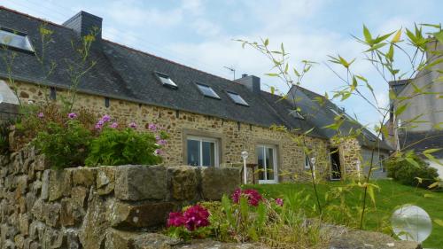 a stone house with a stone wall and flowers at Gite des confitures à Lanvéoc-Crozon in Lanvéoc
