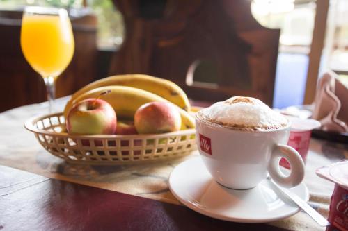 a cup of coffee and a basket of fruit on a table at Merry Pebbles Resort in Sabie