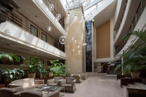 a lobby with couches and plants and a chandelier at Villa Kristina in Truskavets