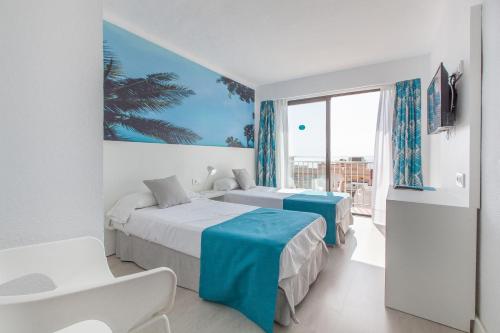 Una habitación de hotel con dos camas y una ventana. en BLUESEA Arenal Tower Adults Only, en El Arenal