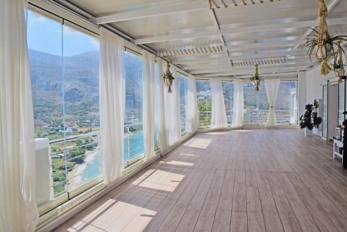 an empty room with windows and a view of the mountains at Aegialis Hotel & Spa in Aegiali
