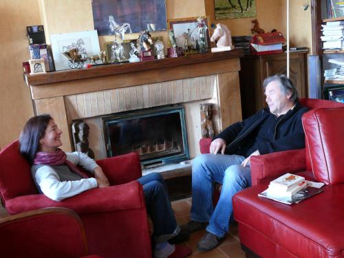 two people sitting in chairs in front of a fireplace at Chambres d'Hôtes La Maison Blanche in Lorp Sentaraille