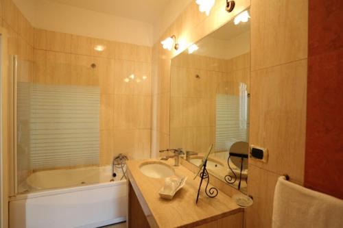 a bathroom with a sink and a tub and a mirror at Bovio Suite in Naples