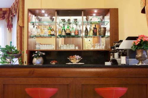 un bar con dos taburetes rojos delante en Alle Torri, en Marghera