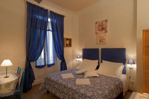 フィレンツェにあるB&B ピーターソンのベッドルーム1室(青いカーテン付きの大型ベッド1台付)