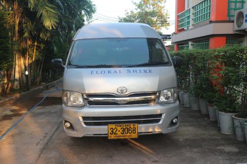 a van parked in a parking lot next to a building at Floral Shire Suvarnabhumi Airport in Lat Krabang