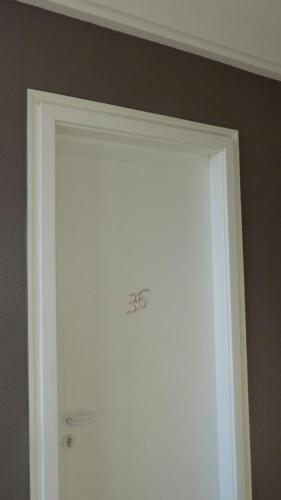 a white door in a room with a wall at Hotel De L'Europe in Toul
