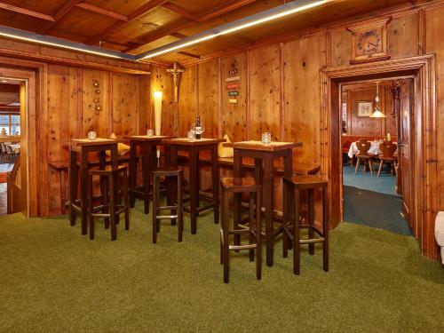 a dining room with wooden walls and tables and stools at Hotel Zum Hirschen in Längenfeld