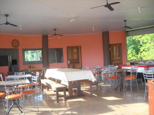 a dining room with tables and chairs in a building at Pousada Chácara Mamma Gaia in Foz do Iguaçu