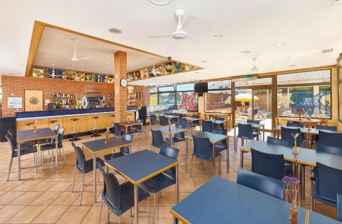 阿尔布费拉海神旅馆公寓的一家有桌椅和酒吧的餐厅