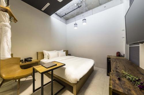 a bedroom with a bed and a desk and a tv at Hotel the Artist Dongdaemun in Seoul