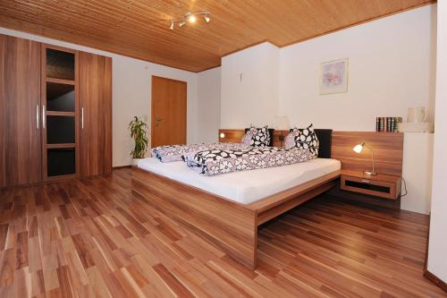a bedroom with a bed and a wooden floor at Appartment Gertrud Flatz in Sankt Anton im Montafon