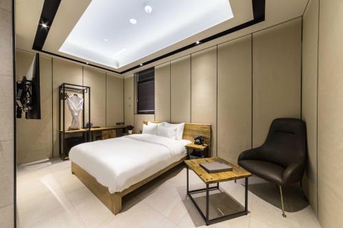 um quarto com uma cama, uma secretária e uma cadeira em Hotel the Artist Dongdaemun em Seul