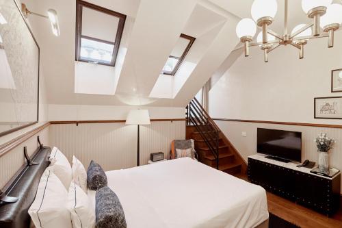 a bedroom with a bed and a tv and windows at Callas House in Budapest