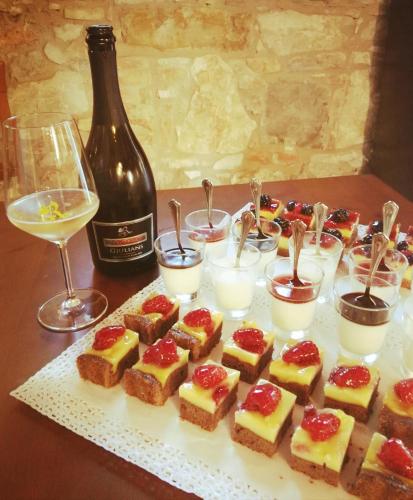 a table with a plate of desserts and a bottle of wine at Agriturismo Villa Trovatore in Cervignano del Friuli