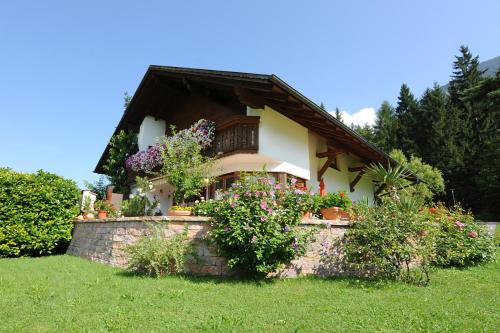 a small house with flowers on a stone wall at Appartment Gertrud Flatz in Sankt Anton im Montafon